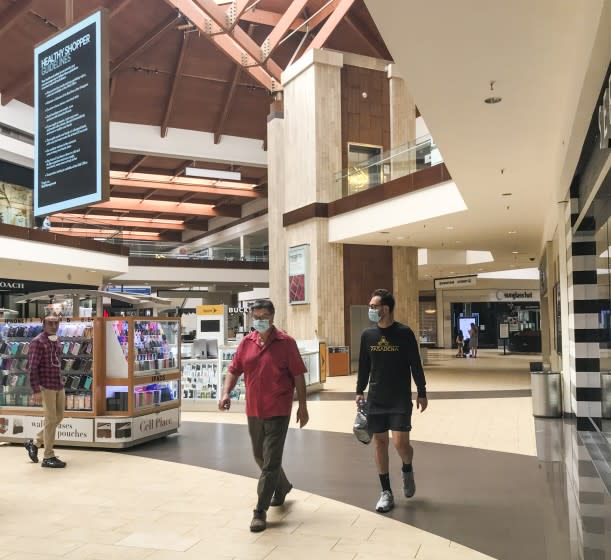 BREA, CA - MAY 26: Shoppers walk around the Brea Mall, which reopened Tuesday, where some of the mall's stores opened their doors to shoppers as the state emerges from shutdown orders enacted to slow the spread of the coronavirus. In new guidelines released yesterday ... the re-opening of retail stores for socially distanced shopping experiences remains subject to approval from officials in each of the state's counties. (Allen J. Schaben / Los Angeles Times)