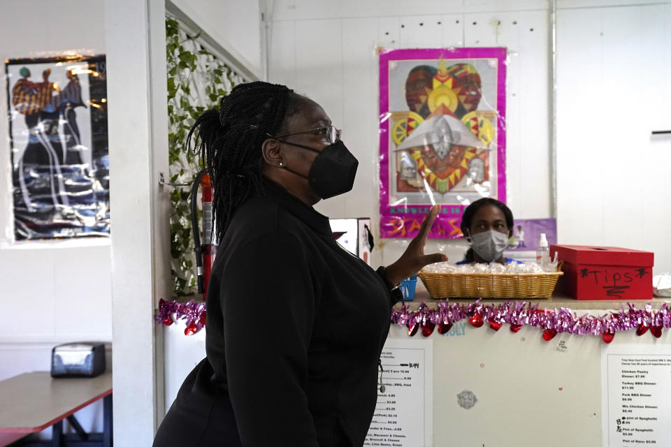 Carolyn Suggs Bandy talks with owner Tracey Knight while picking up take-out food at Tray-Seas Soul Food Restaurant in Princeville, N.C., Monday, Feb. 28, 2022. Bandy proudly gushed about her birthplace, a town that stakes its claim as the oldest chartered by Black Americans nearly 140 years ago. (AP Photo/Gerry Broome)