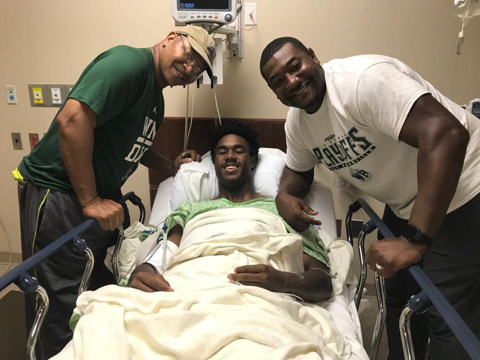 West Bloomfield running back Donovan Edwards is flanked by Tyrice Grice, left, and head coach Ron Bellamy after surgery to repair his broken leg Tuesday, Oct. 9, 2018.