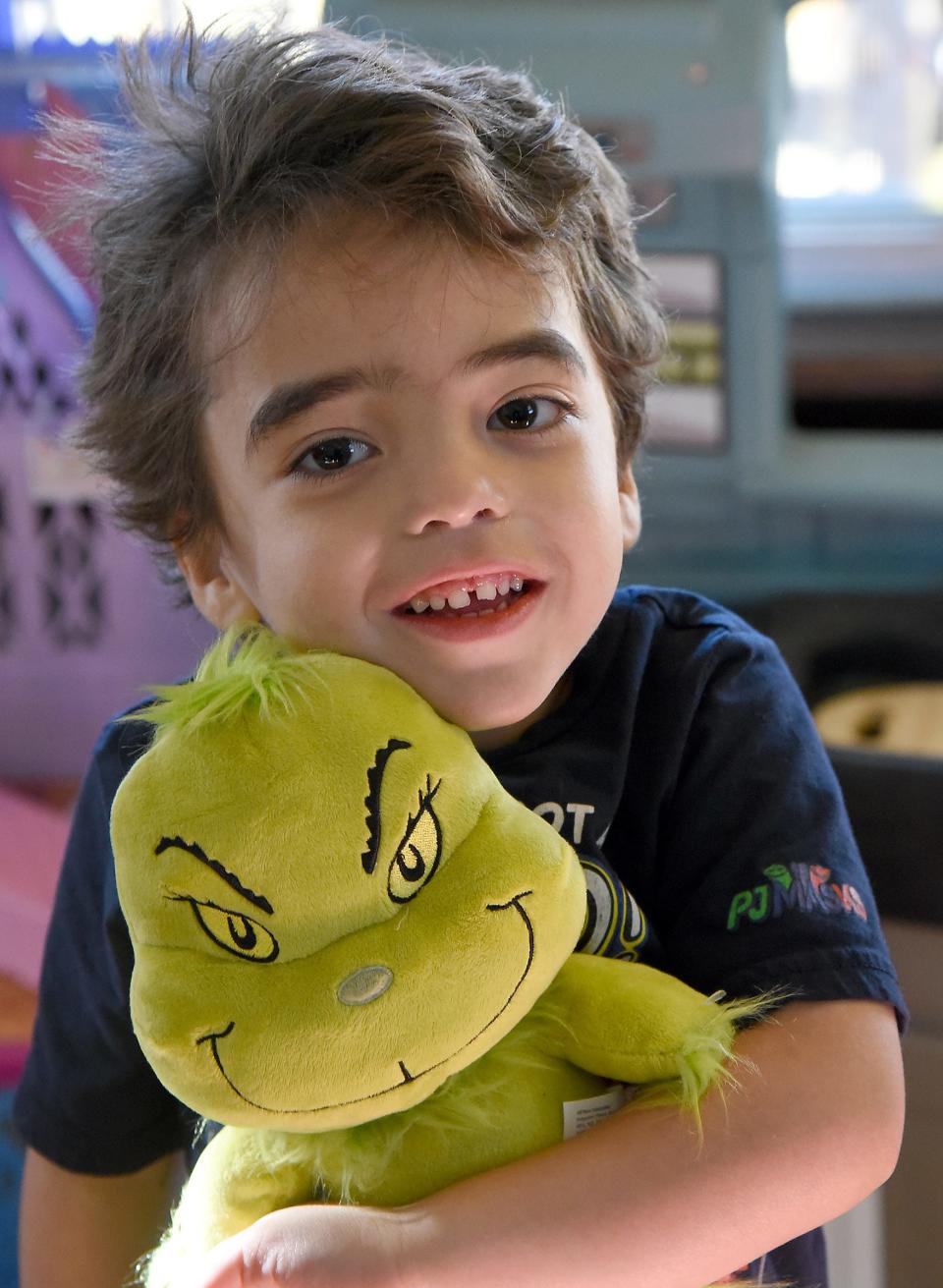 Elliott Althouse, of Monroe, who turns 5 years old today, hugs the Grinch toy he brought home from the family's Make-A-Wish vacation in Walt Disney World. The theme for his birthday party is the Grinch. Elliott is dealing with a very rare syndrome called Lennox-Gastaut Syndrome, a lifelong and aggressive form of epilepsy.