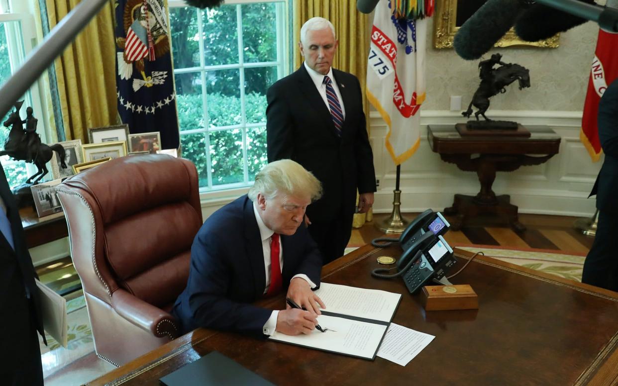 Donald Trump signs an executive order imposing new sanctions on Iran as Vice President Mike Pence (R) looks on - Getty Images North America