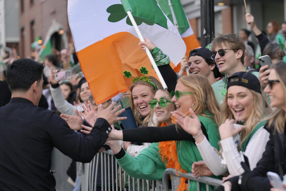 A firefighter greets spectators as they watch the St. Patrick's Day parade, Sunday, March 17, 2024, in Boston's South Boston neighborhood. (AP Photo/Steven Senne)