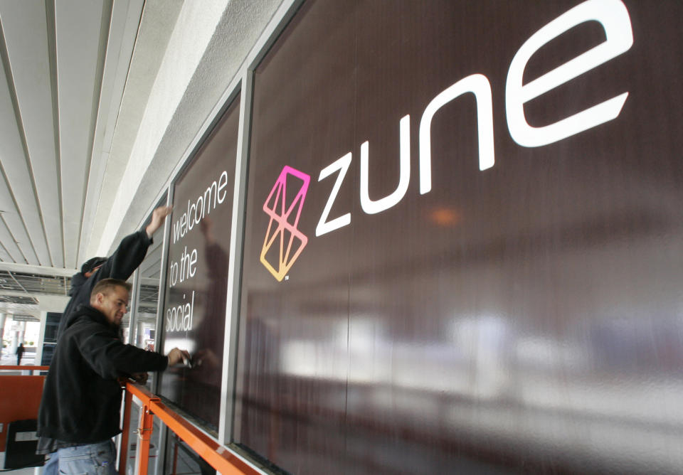 Convention workers put up an advertisement for Zune, Microsoft's portable multimedia player, outside the Las Vegas Convention Center as they prepare for the 2007 International Consumer Electronics Show (CES) in Las Vegas, Nevada January 5, 2007. This year's show runs from January 8-11 and is expected to draw over 150,000 attendees.   REUTERS/Steve Marcus   (UNITED STATES)