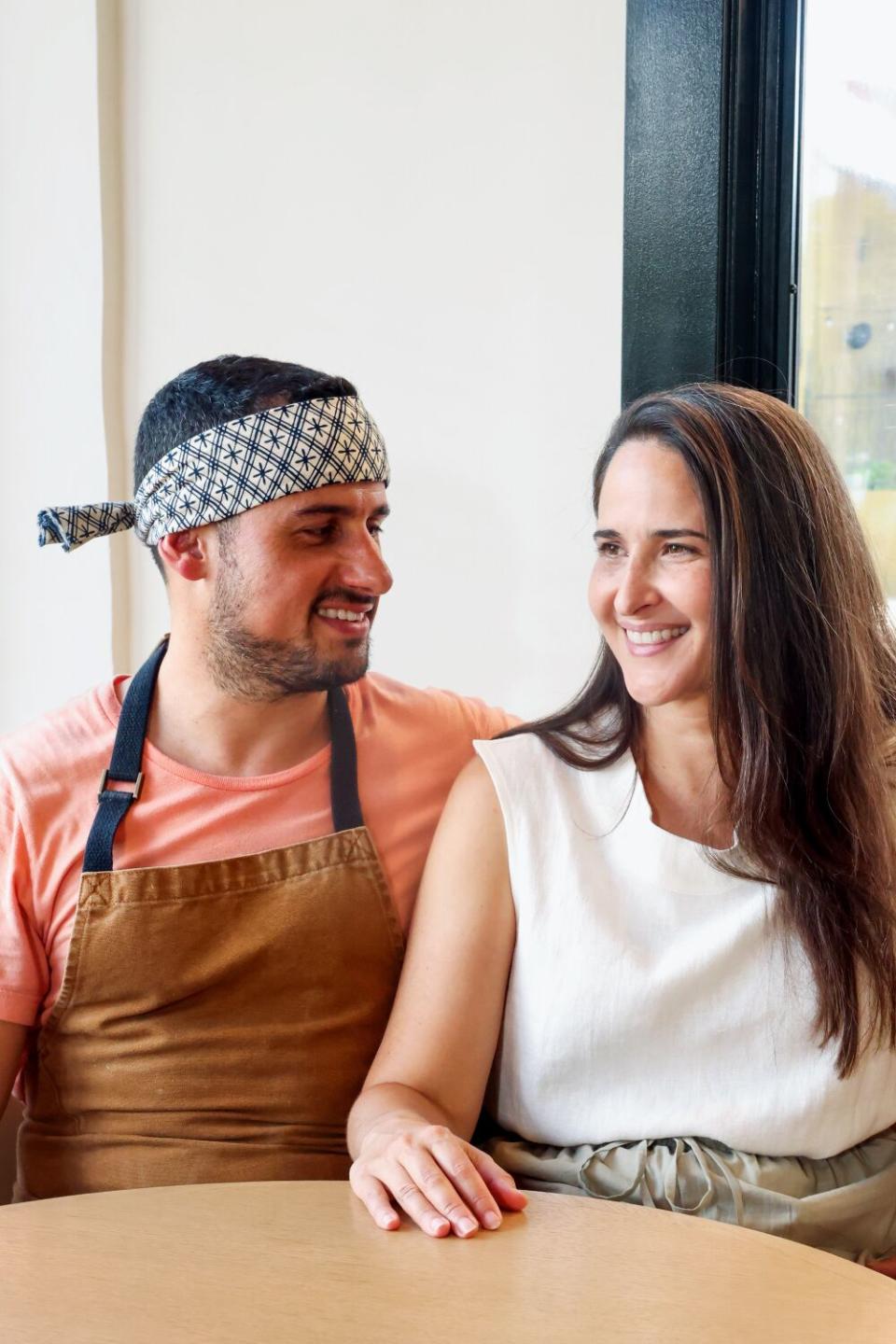 Ori Menashe, left, and Genevieve Gergis, right, sitting in a booth indoors.