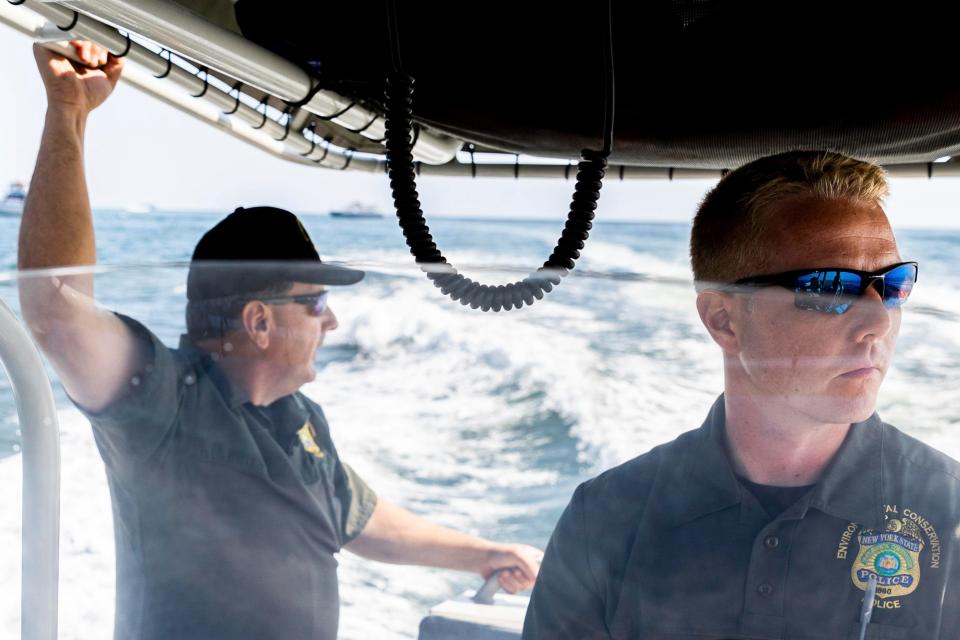 Lt. Sean Riley and Zachary Kochanowski, environmental conservation officers with the New York State Police, patrol for sharks in the ocean off of Robert Moses State Park in Babylon, New York.