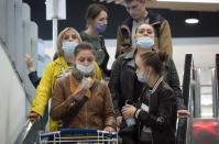 People wearing face masks to protect against coronavirus infection leave a mall in St.Petersburg, Russia, Friday, Sept. 11, 2020. Russia has seen an uptick in new cases of coronavirus in recent weeks and hospitalizations have started to increase. (AP Photo/Dmitri Lovetsky)