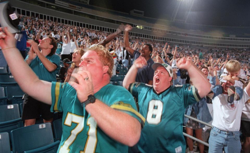 Andy Doyle, left, and brother Shannon Doyle cheer with other Jaguars fans as they watch the team beat the Denver Broncos on the Jacksonville stadium TV during the Jan. 4, 1997, playoff matchup.