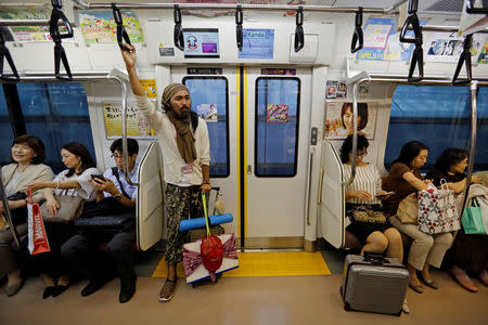 Tokuchika Nishi (C), a 38-year-old homeless man and a member of Newcomer "H" Sokerissa! - a group of current and former homeless dancers, rides a train in Tokyo, Japan, September 7, 2017. REUTERS/Toru Hanai