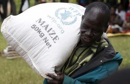 A Malawian man carries food aid distributed by the United Nations World Food Progamme (WFP) in Mzumazi village near the capital Lilongwe, February 3, 2016. REUTERS/Mike Hutchings