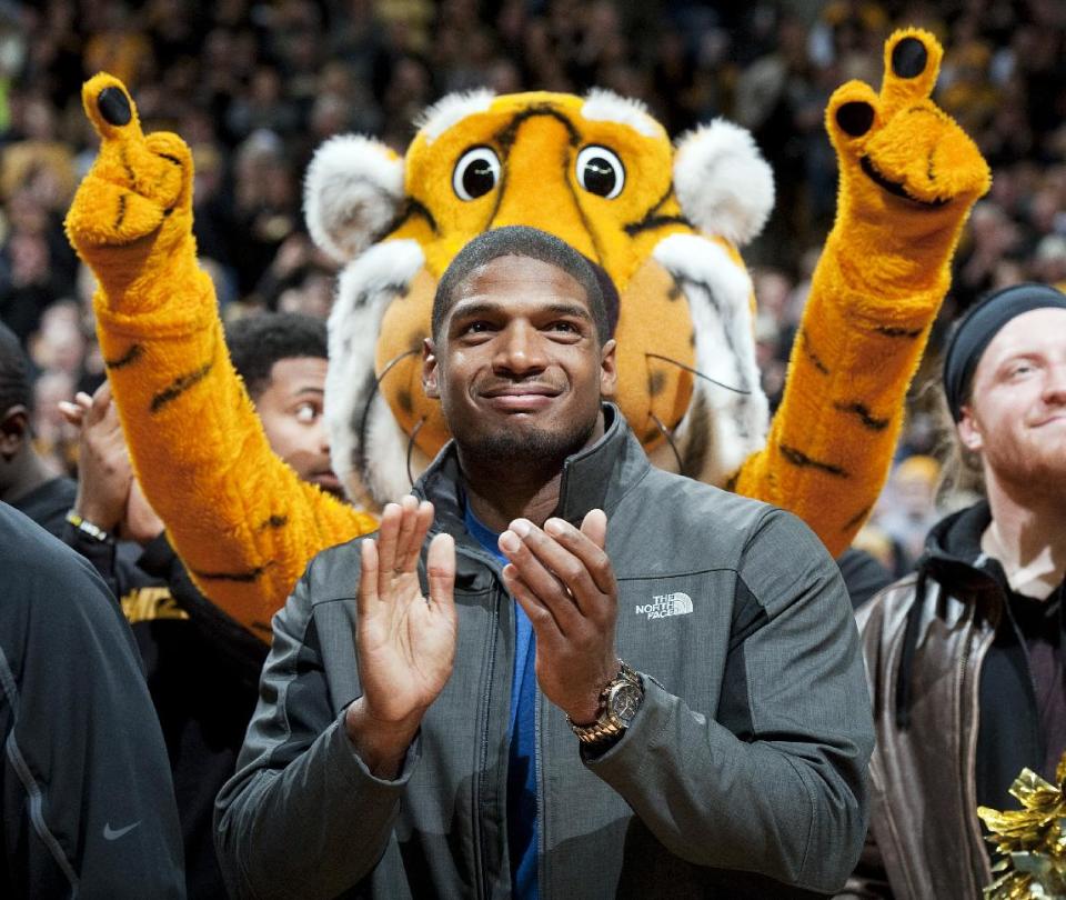 Missouri's All-American defensive end Michael Sam claps during the Cotton Bowl trophy presentation at halftime of an NCAA college basketball game between Missouri and Tennessee, Saturday, Feb. 15, 2014, in Columbia, Mo. Sam came out to the entire country Sunday, Feb. 9, and could become the first openly gay player in the NFL. (AP Photo/L.G. Patterson)