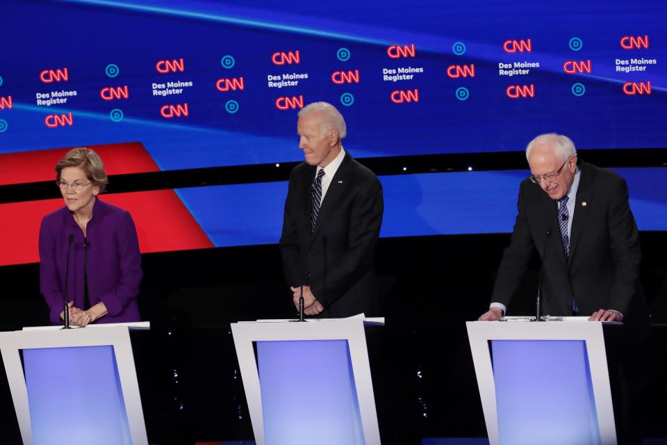 Sen. Elizabeth Warren (D-MA) speaks as former Vice President Joe Biden and Sen. Bernie Sanders (I-VT) (R) listen during the Democratic presidential primary debate at Drake University on January 14, 2020 in Des Moines, Iowa.  Six candidates out of the field qualified for the first Democratic presidential primary debate of 2020, hosted by CNN and the Des Moines Register.