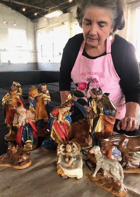 Hulett Kitterman sets out a hand-carved and hand-painted Italian manger scene owned by Monica Cain that will be on display during the exhibit Dec. 1-4.