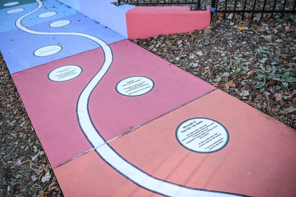 Durham said he envisioned a board game for his sidewalk mural. "It was like I was playing 'Chutes and Ladders.'"