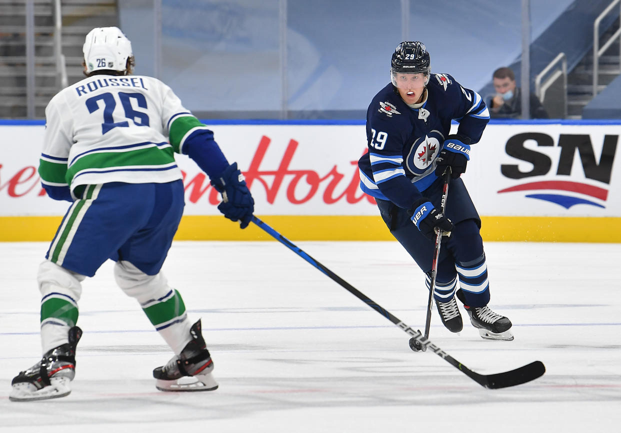 EDMONTON, ALBERTA - JULY 29: Patrik Laine #29 of the Winnipeg Jets skates the puck through the neutral zone against Antoine Roussel #26 of the Vancouver Canucks during the first period of an exhibition game prior to the 2020 NHL Stanley Cup Playoffs at Rogers Place on July 29, 2020 in Edmonton, Alberta. (Photo by Andy Devlin/NHLI via Getty Images)