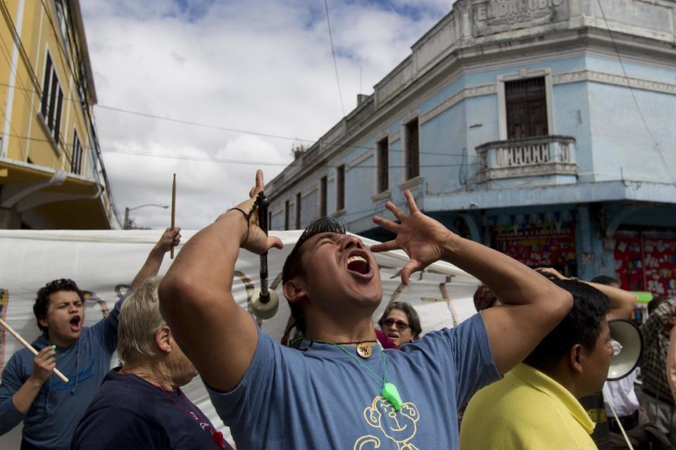 In this Jan. 14, 2017 photo, demonstrators chant slogans against Guatemala's President Jimmy Morales outside Congress as he delivers his first annual State of the Nation address in Guatemala City. (AP Photo/Moises Castillo)