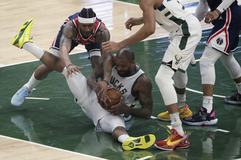 Milwaukee Bucks' P.J. Tucker and Washington Wizards' Bradley Beal compete for possession of the ball during the first half of an NBA basketball game Wednesday, May 5, 2021, in Milwaukee. (AP Photo/Aaron Gash)