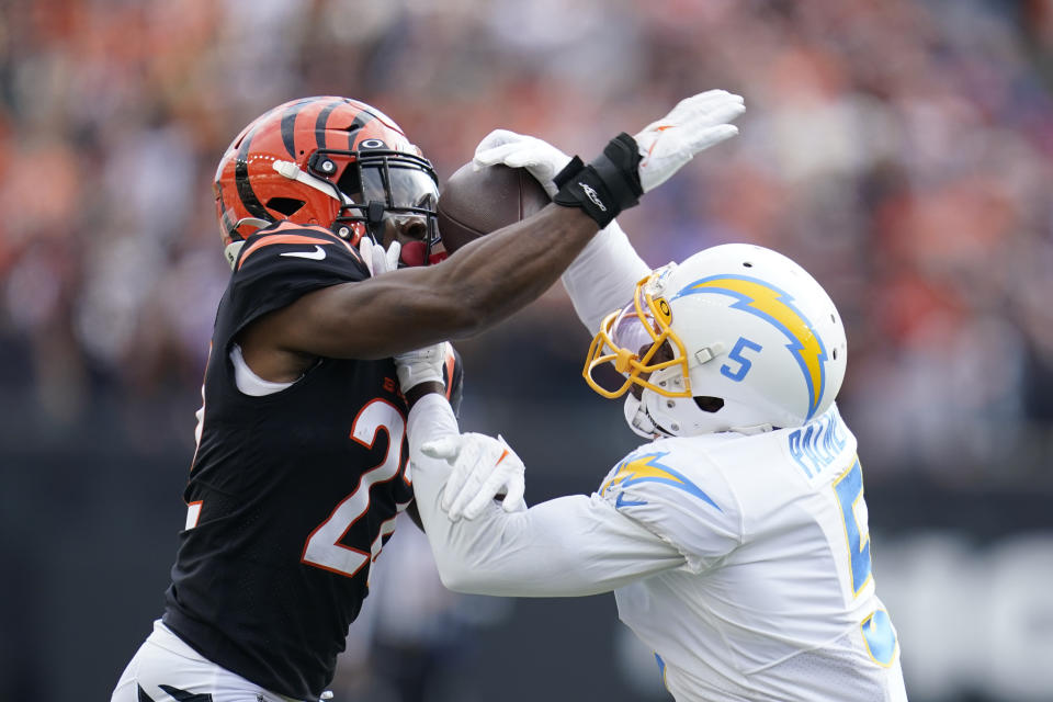 Cincinnati Bengals' Chidobe Awuzie (22) intercepts a pass intended by Los Angeles Chargers' Josh Palmer (5) during the first half of an NFL football game, Sunday, Dec. 5, 2021, in Cincinnati. (AP Photo/Michael Conroy)