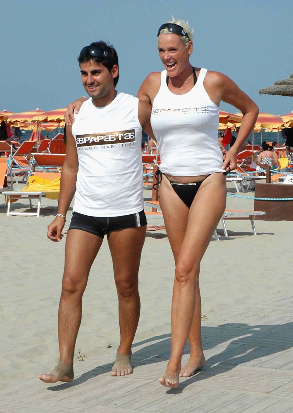 Brigitte Nielsen and her husband Mattia Dessi walk on the beach on July 29, 2005 in Cervia, Italy