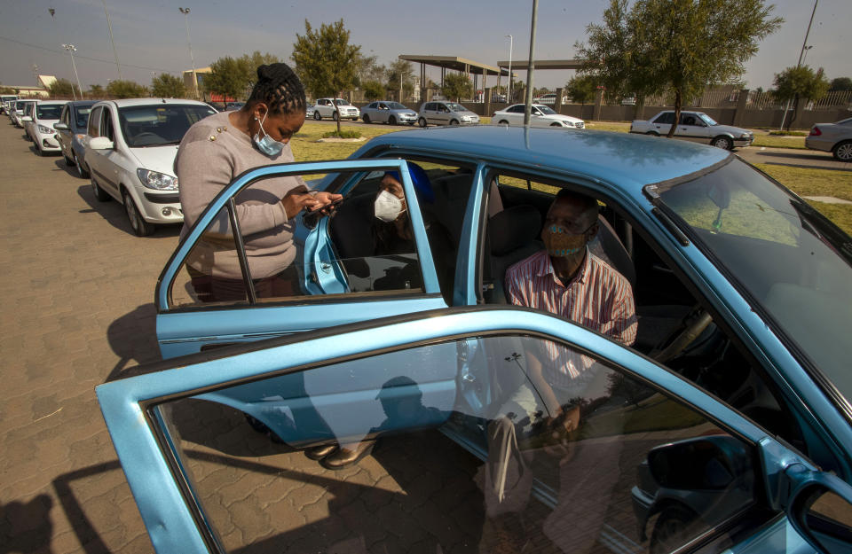 Health worker checks the documents of seniors getting vaccinated with the first dose of Pfizer's coronavirus vaccine at the newly-opened mass vaccination program for the elderly at a drive-thru vaccination center in Johannesburg, South Africa, Tuesday, May 25, 2021. South Africa aims to vaccinate 5 million of its older citizens by the end of June. (AP Photo/Themba Hadebe)