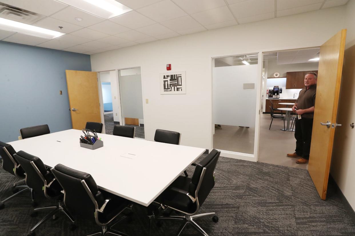 Mark Yenny, community manager at HQ, shows a conference room that is available to office and space users at the AES building location in Akron.