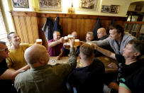 Customers cheer with beer as a traditional beer pub opens in Prague, Czech Republic, Monday, May 25, 2020. The bars, restaurants and cafes are returning to full service in the Czech Republic as the government is taking further steps to ease its restrictive measures adopted to contain the coronavirus pandemic. (AP Photo/Petr David Josek)