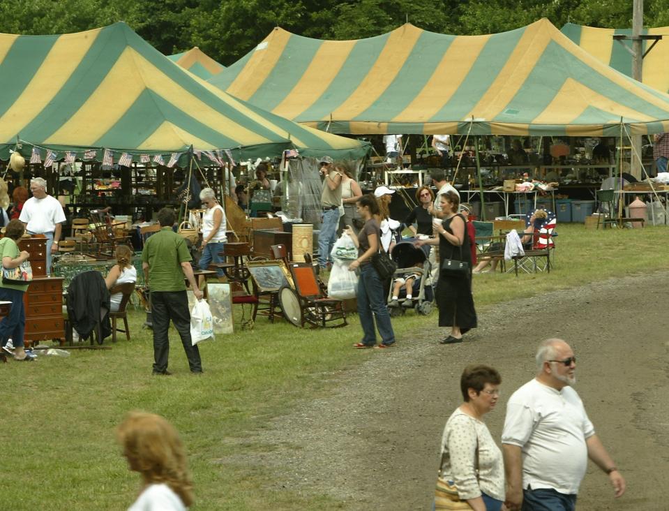 Shoppers peruse the wares at the Utica Antiques Market located on the Knights of Columbus Grounds in 2003. The market is been hosted for 38 years and features over 100 tents and draws hundreds of customers a day.