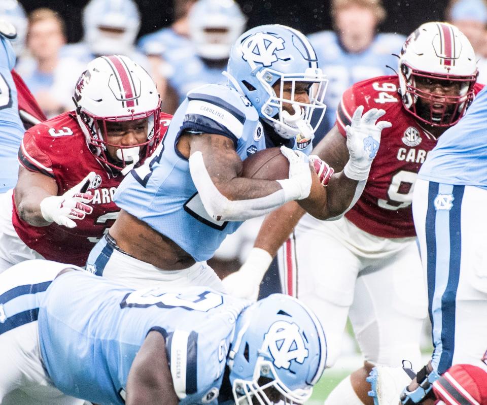 North Carolina Tar Heels running back British Brooks (24) attempts to get through South Carolina Gamecocks defense during the Duke's Mayo Bowl at Bank of America Stadium in Charlotte on Thursday, December 30, 2021.