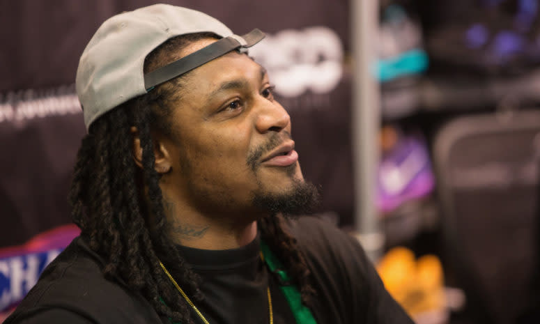 Marshawn Lynch wearing a backwards hat.