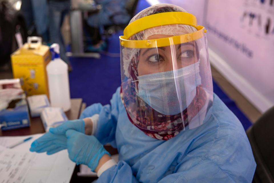 A health worker wearing protective gear at a drive-through test centre (AP)