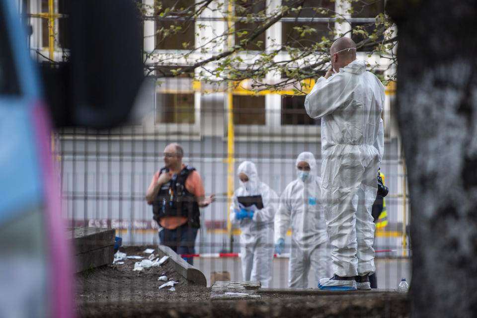 Forensics staff stand near the 'Protestant School Neukoelln' in Berlin, Germany, Wednesday, May 3, 2023. Berlin police say two young children were seriously wounded in an attack at a school in the south of the capital. Police said the victims were girls aged 7 and 8 years. One is in a life-threatening condition, they said in a statement. (Christophe Gateau/dpa via AP)