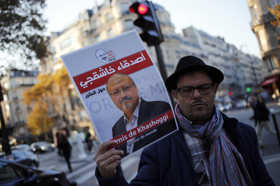 An activist holds a portrait reading "Friends of Khashoggi around the world" as part of a protest closed to the Saudi Arabia embassy, in Paris, Thursday, Oct. 25, 2018. Saudi prosecutors say the killing of journalist Jamal Khashoggi was planned, state-run media reported Thursday, reflecting yet another change in the shifting Saudi Arabian account of what happened to the writer who was killed by Saudi officials in their Istanbul consulate. (AP Photo/Francois Mori)