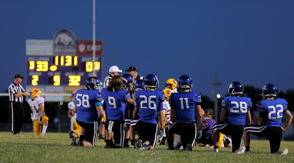 The Centerville Bulldogs kneel for an injured player during a game against Hagerstown Aug. 26, 2022.