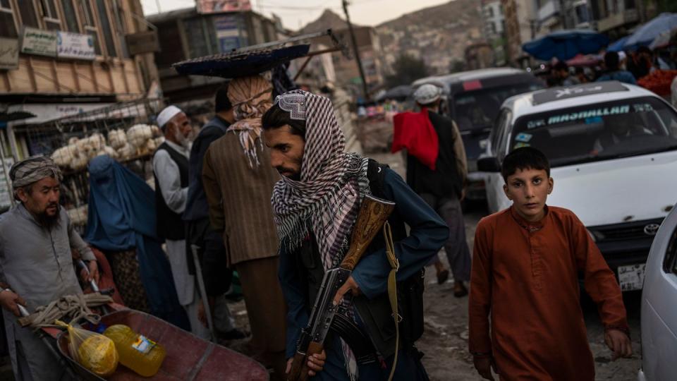 Ein Taliban-Kämpfer patrouilliert auf einem Markt in Kabul (Symbolbild).