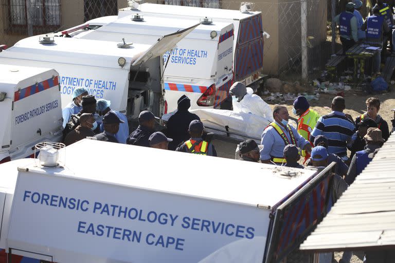 Lo servicios de emergencia en la taberna en East London, Sudáfrica, donde se encontraron muertos a varios jóvenes el 26 de junio del 2022.  (Foto AP)