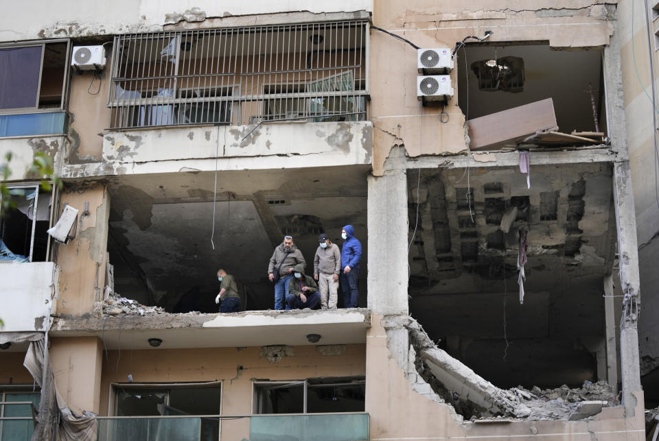 Investigators stand on an apartment building where an apparent Israeli strike Tuesday killed top Hamas political leader Saleh Arouri, in the southern suburb of Beirut that is a Hezbollah stronghold, Lebanon, Wednesday, Jan. 3, 2024. The apparent Israeli strike that killed Hamas' No. 2 political leader, marking a potentially significant escalation of Israel's war against the militant group and heightening the risk of a wider Middle East conflict. (AP Photo/Hussein Malla)