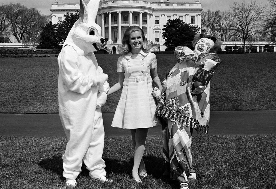 <p>Tricia Nixon walks the White House grounds in Washington, March 27, 1970, with a couple of Springtime friends – circus clown Bobby Kay and the Easter Bunny, a White House staffer who prefers to remain anonymous. (Photo: Henry Burroughs/AP) </p>