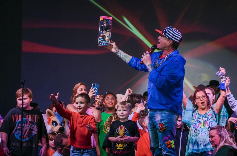 Rapper Vanilla Ice holds up a toy version of himself while performing on the mainstage during Winterfest in Wellington, Florida, in December 2021.