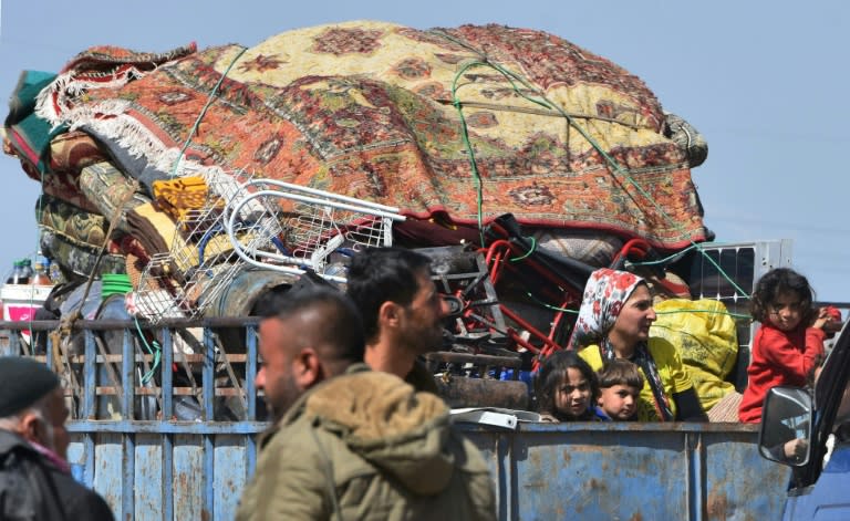 Civilians fleeing Afrin arrive in the village of az-Ziyarah in the government-controlled part of the northern Aleppo province