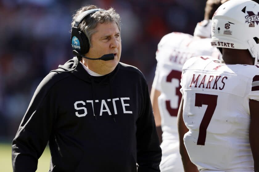 Mississippi State head coach Mike Leach talks with players during a timeout.