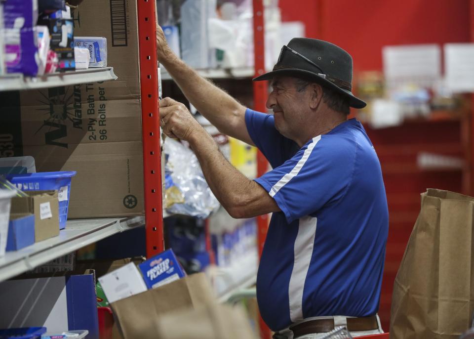 Scott Frazier stocks shelves on Thursday, August 4, 2022, at Operation Bootstrap in Stevens Point, Wis.