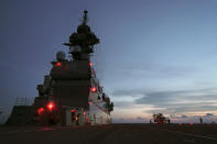 FILE - In this June 26, 2019, file photo, aircraft maintenance engineers prepare to stow away an SH-60K helicopter on the flight deck aboard Japan's Maritime Self-Defense Force helicopter carrier JS Izumo (DDH-183) along a sea route heading northward from Brunei towards Sulu Sea. Japan approved Friday, Dec. 20, 2019, a draft defense budget that included cost to develop own fighter jets to succeed the nation's aging warplanes and import some of F-35 stealth fighters as components for assembly at home rather than importing the expensive American warplanes as finished products to reduce costs and acquire expertise. To accommodate the F-35Bs, the Defense Ministry will spend 3.1 billion yen ($290 million) to reconfigure one of its two helicopter carriers, Izumo, with a heat-resistant flight deck and guiding lights, beginning next year. (AP Photo/Emily Wang, File)