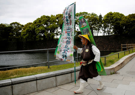 Korean resident in Japan, Kim Fuzan in traditional pilgrim attire walks along the Imperial Palace as he wishes a successful abdication for the emperor in Tokyo, Japan, April 29, 2019. REUTERS/Kim Kyung-hoon