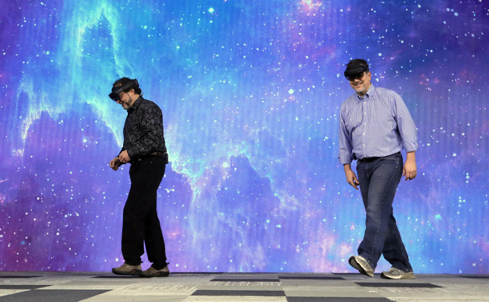 Two men smile as they walk offstage after what was to be a recreation of the Apollo 11 mission to the moon using the HoloLens 2 failed to work before the keynote address at Microsoft's Build, the company's annual conference for software developers Monday, May 6, 2019, in Seattle. (AP Photo/Elaine Thompson)