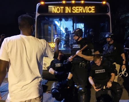 Police officers wearing riot gear block a road during protests after police fatally shot Keith Lamont Scott in the parking lot of an apartment complex in Charlotte, North Carolina. REUTERS/Adam Rhew/Charlotte Magazine