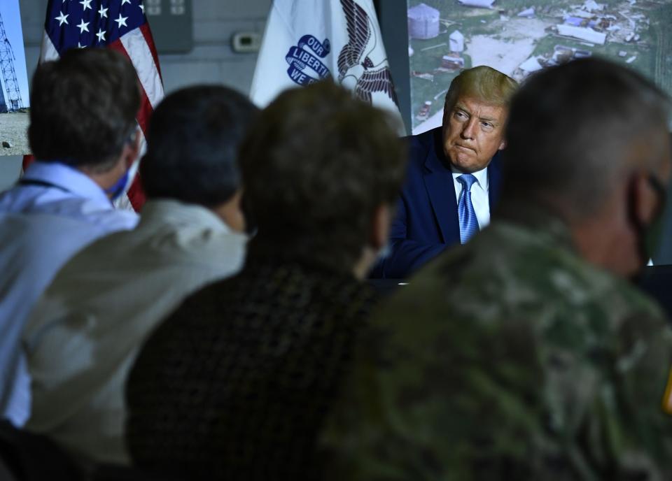 President Donald Trump is briefed on disaster recovery efforts Aug. 18 at the Eastern Iowa Airport in Cedar Rapids.