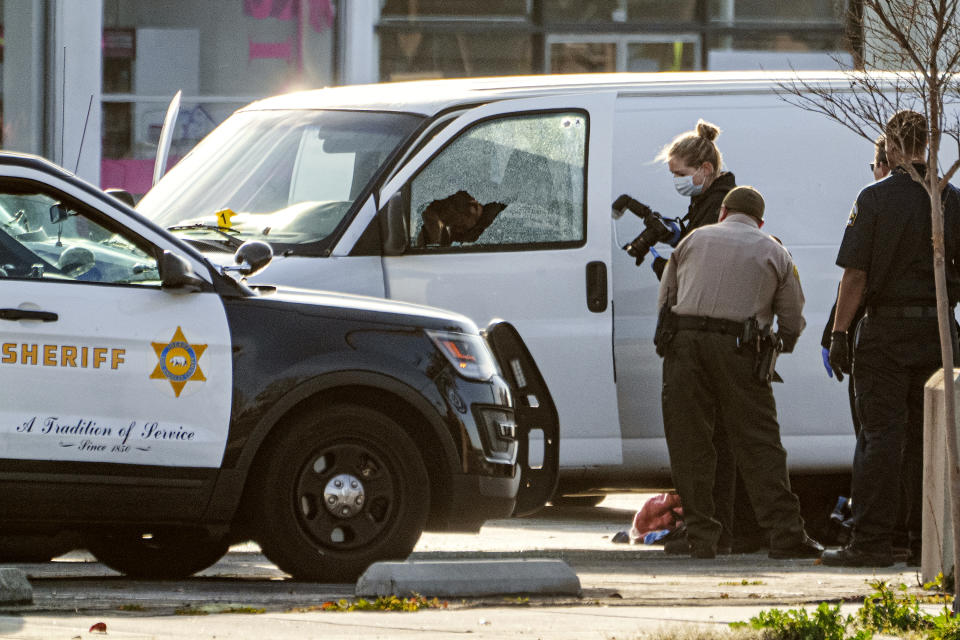 A body is seen on the driver's side of a van as authorities investigate, in Torrance, Calif., Sunday, Jan. 22, 2023. Authorities say the driver, the suspect in a California dance club shooting that left multiple people dead, shot and killed himself. (AP Photo/Damian Dovarganes)