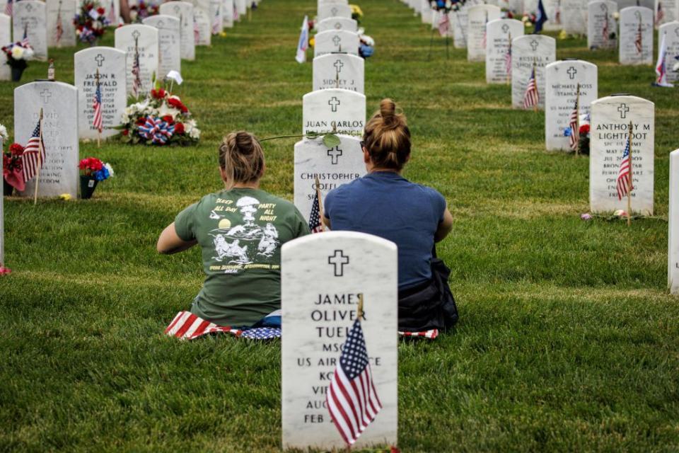Two women visit a fallen loved one at Arlington National Cemetery on Memorial Day.