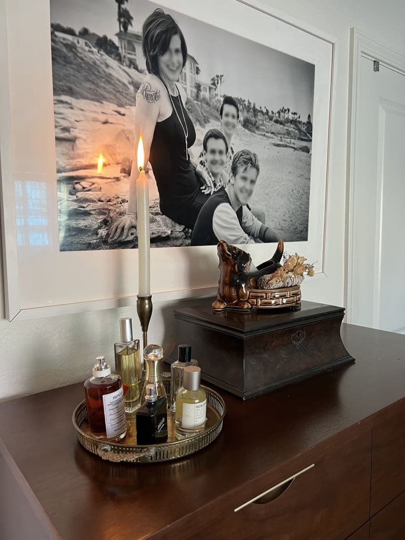 Perfume and items on dresser with family photo above