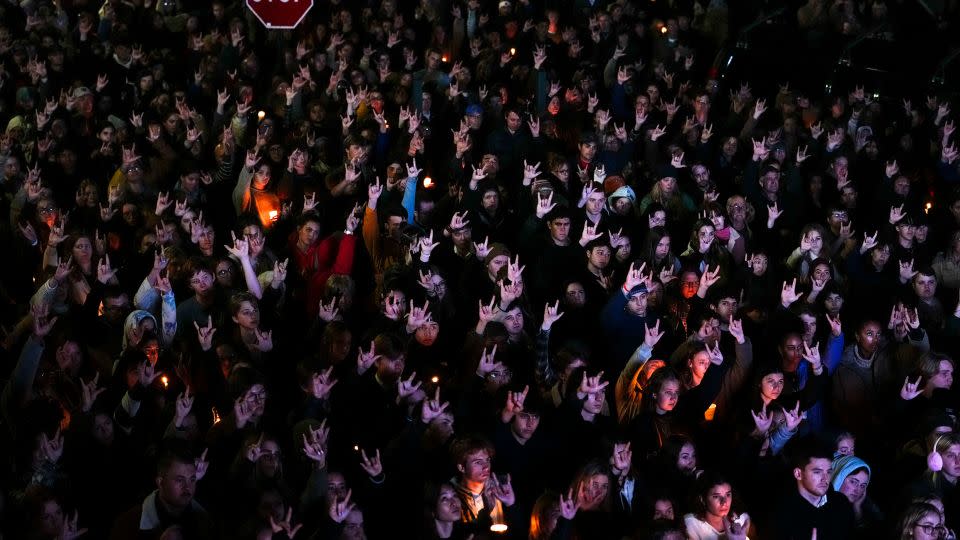 People sign "I love you" at a vigil for victims of last month's mass shooting in Lewiston, Maine. - Matt Rourke/AP