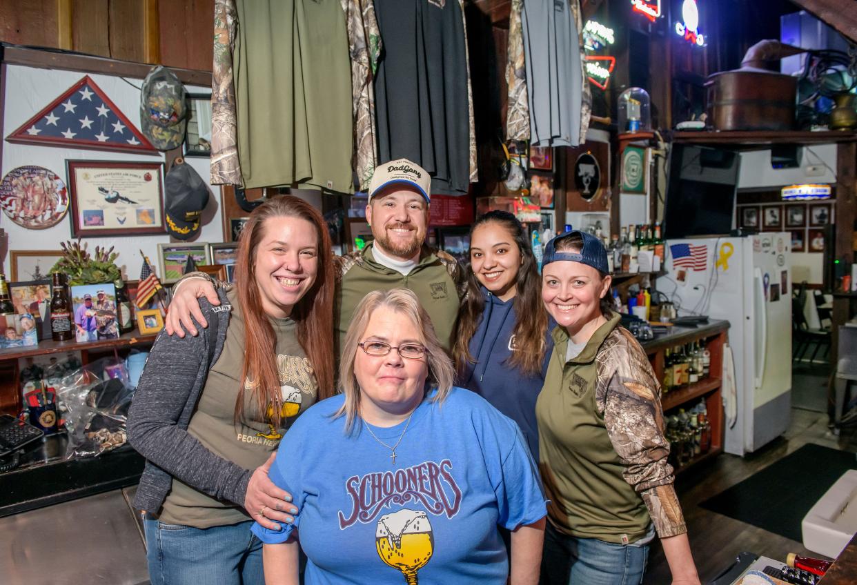 Schooners employees Angie Hrdlicka, foreground, and, from left to right in the back, Briana Davis, Brad Gebhards, Alyssa Rodriguez and Jen Kuntz, pose behind the bar at the popular bar and grill on War Memorial Drive in Peoria Heights.